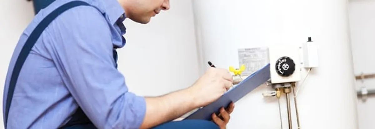 Water heater repair technician inspecting the unit and recording service notes in Richmond, VA